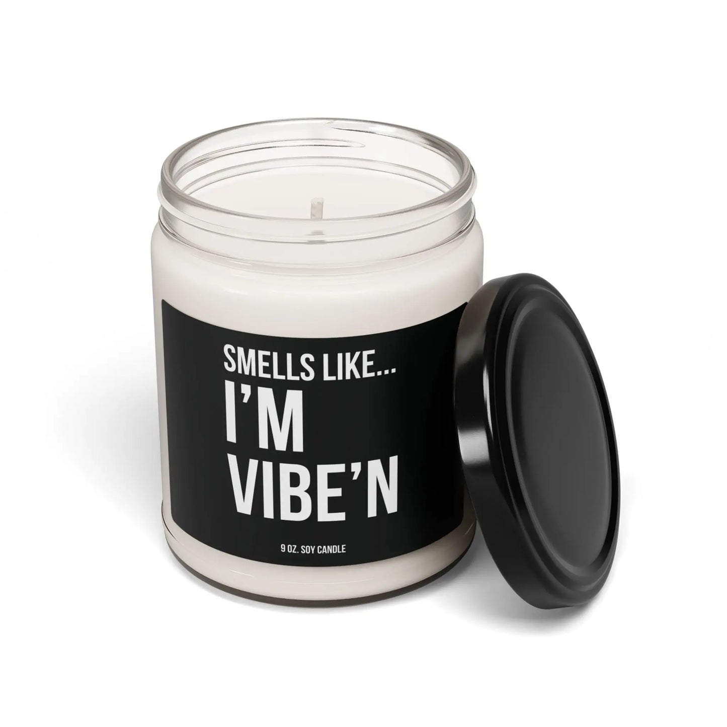 Open lid view of Urban Cookie’s “Smells Like I’m Vibe’n” 9 oz soy candle in a minimalist clear jar with White text on a black label with a sleek black lid, exuding a fresh, bold aroma and cool vibe.