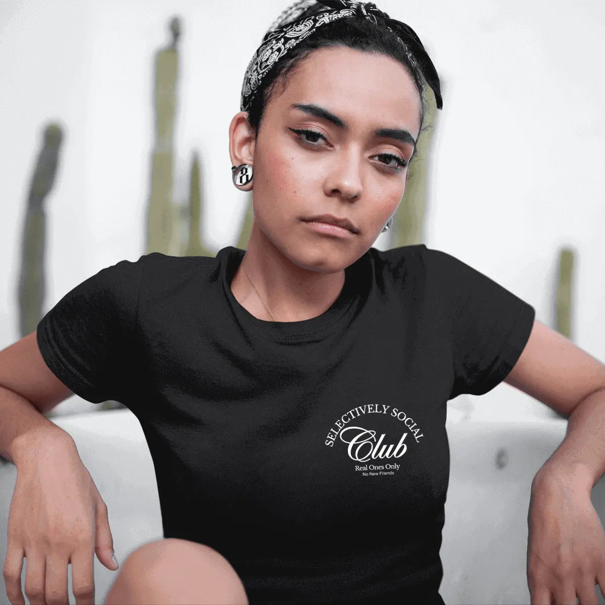 Serious face edgy young woman woman sitting in a tub wearing a Selectively Social Club from Urban Cookie.